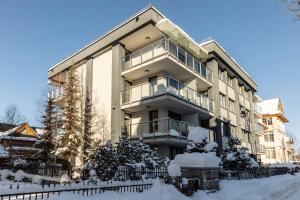 a large apartment building in the snow at Tatry Top Apartamenty Granitica centrum in Zakopane