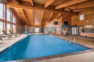 a pool in a large room with a wooden ceiling at AmericInn by Wyndham Detroit Lakes in Detroit Lakes