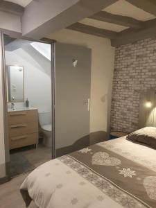 a bedroom with a large bed and a bathroom at Appartement in Noyen-sur-Sarthe