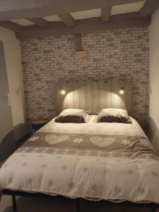 a bedroom with a large bed with a brick wall at Appartement in Noyen-sur-Sarthe