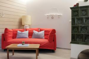 a red couch in a living room with a table at CASA 4 PIOPPI - Vista Lagorai e tranquillità a Cavalese - Dolomiti Affitti in Cavalese