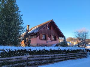 a house covered in snow next to a fence at Le Saptésien in Ban-de-Sapt