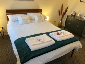 a hotel room with a bed with towels on it at Lavender Cottage in Thirsk