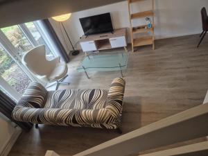 a living room with a couch and a tv at James' Place @1 Gwynnes in Merthyr Tydfil