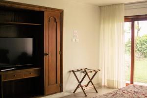 a bedroom with a flat screen tv and a bed at Hotel Belén Boutique in Manizales