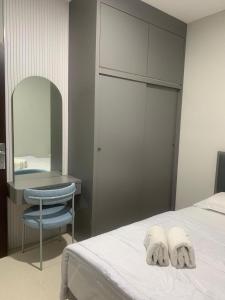 a bedroom with a bed and a desk and a mirror at Skyline Z in Mantaak +2 photos