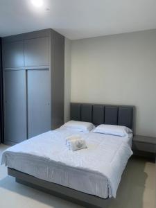 a bedroom with a large white bed with a black headboard at Skyline Z in Mantaak