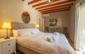 a bedroom with a large white bed and a mirror at Casa Maria in Santa Maria del Camí