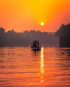 a group of people in a boat on the water at sunset at Eden homes in Honāvar