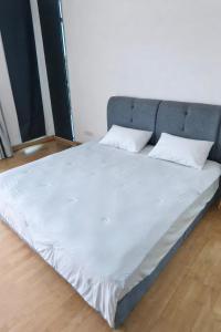 a large bed with white sheets and pillows on it at Lakeside house in Gua Sai