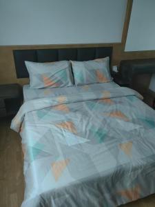 a bed with a colorful comforter and pillows at Lakeside house in Gua Sai +3 photos