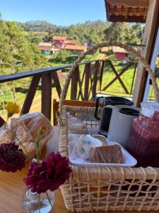 a basket sitting on a table with food in it at Chalé Sonho Diniz 3 in Monte Verde