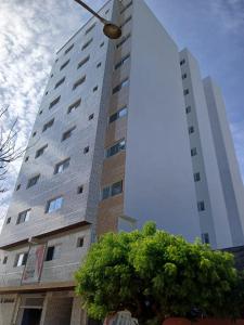 a tall building with a tree in front of it at FASARESIDENCE Dakar Point E CHAMBRE NOFLAYE in Dakar