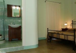 a bathroom with a sink and a bed and a mirror at La Casa dellAmericano - Casa d'epoca anni '30 in Aliano +21 photos