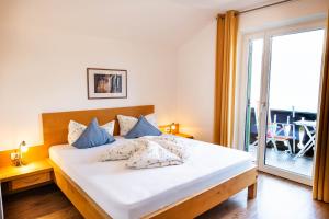 a bedroom with a large white bed with blue pillows at Pension Chalet Andy in Schenna +41 photos