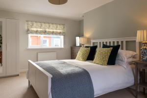 a bedroom with a large white bed with yellow pillows at Easy Oars - Flushing, Falmouth in Flushing
