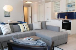 a living room with a couch and a table at Prora Block 1 - Sauna, Pool und Fitness - Meerzeit in Binz