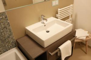a bathroom with a white sink and a bath tub at Prora Block 1 - Sauna, Pool und Fitness - Meerzeit in Binz +21 photos