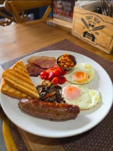 a plate of breakfast food with eggs sausage and toast at Grace Villas 28 in East London