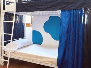 a bunk bed in a dorm room with an apple wall at Rio Hostel in Seville