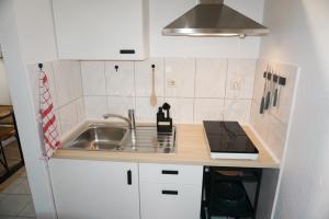 a small kitchen with a sink and a counter at Apartment Café Ettelbrück in Ettelbruck +3 photos