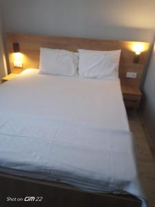a bed with white sheets and pillows in a room at Tekirdağ Begonya Hotel in Kapaklı +2 photos