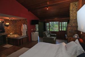 una habitación de hotel con una cama y un baño en Caminho do Marimbondo, en Visconde De Maua