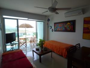 Sala de estar con cama, TV y mesa en Costa Azul Suites 802 en Santa Marta