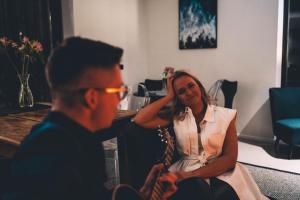 a woman sitting next to a man in a room at Hõbekala Guesthouse in Kalana