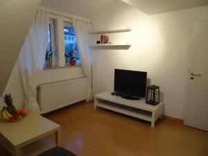 a living room with a television on a white table at Ferienwohnung Strunz Backnang ruhig zentrumsnah & S-Bahn in Backnang