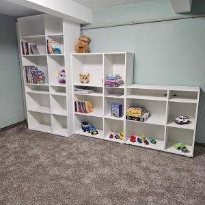 a white book shelf filled with lots of toys at Willa Rodzinna in Wisła