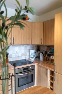 a kitchen with wooden cabinets and a stove top oven at ZEN MARINA in Mandelieu-La Napoule