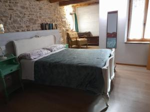 a bedroom with a bed and a stone wall at Casa 1885 in Belluno