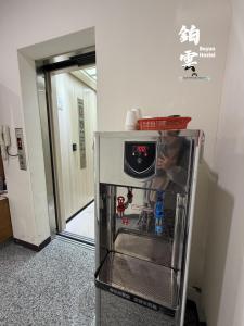 a small refrigerator with a clock on top of it at Boyun Hostel in Kaohsiung
