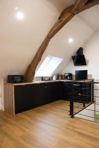 an attic kitchen with black cabinets and a window at L'auberge du Paon in Troyes