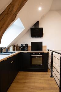 a kitchen with black cabinets and a window at L'auberge du Paon in Troyes +20 photos