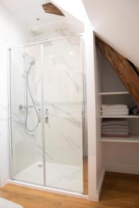 a shower with a glass door in a bathroom at L'auberge du Paon in Troyes