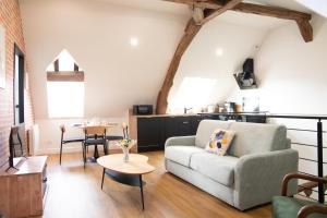 a living room with a couch and a table at L'auberge du Paon in Troyes