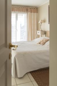 a bedroom with a white bed and a window at ZEN MARINA in Mandelieu-La Napoule