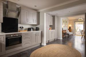 a kitchen with white cabinets and a rug at Easy Oars - Flushing, Falmouth in Flushing