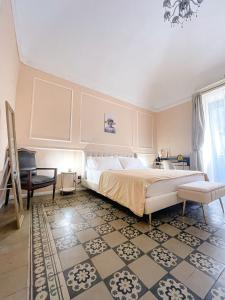 a bedroom with a large bed and a chair at Flame B&B in Catania
