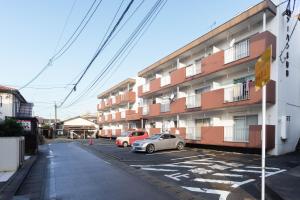 two cars parked in a parking lot in front of a building at Kasuga Good Place House in Kasugabaru +30 photos