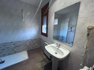 a bathroom with a sink and a mirror and a tub at Rosaleda Self-Hotel in Fondarella +3 photos