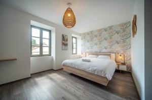 a bedroom with a bed and a pendant light at Les Trésors de Givry in Givry