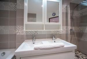 a bathroom with a white sink and a mirror at Les Trésors de Givry in Givry +18 photos