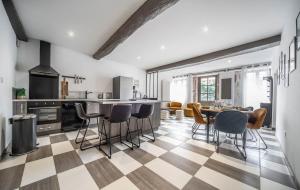 a kitchen with a checkered floor and a table and chairs at Les Trésors de Givry in Givry