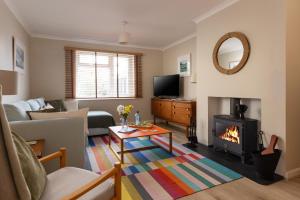 a living room with a couch and a fireplace at Easy Oars - Flushing, Falmouth in Flushing