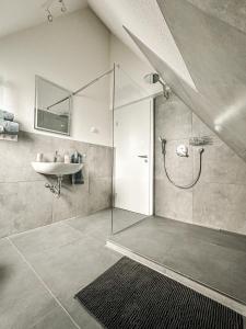 a bathroom with a shower and a sink and a sink at Pension Elisa in Bad Friedrichshall +89 photos