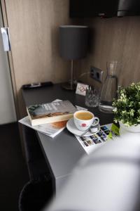 a desk with a cup of coffee and magazines at N9 Hotel Nürnberg-City in Nuremberg +17 photos