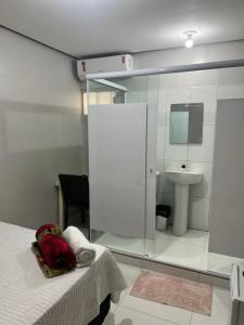 a room with a bed and a bathroom with a sink at Hotel Santa Rita in Amarante do Maranhão